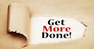 A creative illustration featuring a torn piece of beige parchment paper revealing a hidden message beneath. The phrase "Get More Done!" is prominently displayed in bold, contrasting text (black for "Get" and "Done," red for "