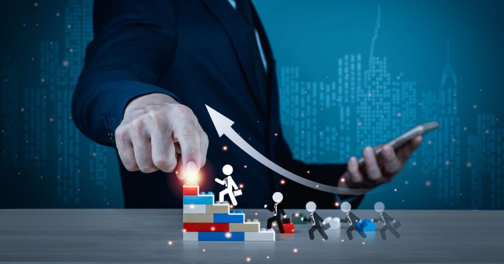 A businessman in a dark suit points his index finger toward the glowing tip of an upward-curving arrow, which originates from a stack of multicolored building blocks. Small stick-figure climbers ascend the blocks, carrying briefcases and progressing toward the arrow’s peak. The scene is set against a futuristic blue cityscape with illuminated skyscrapers, symbolizing ambition, strategic growth, and collective progress. The imagery conveys leadership, innovation, and the collaborative effort required to achieve upward mobility in a dynamic business environment.