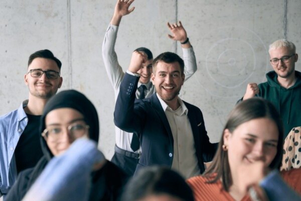 A group of people enthusiastically raising their hands