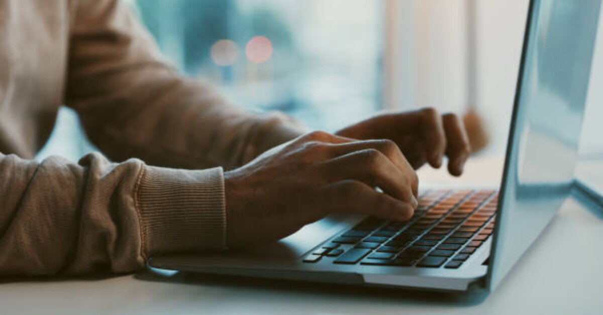 Individual using a laptop, contributing to authentic workplace dynamics.