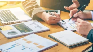 Business team analyzing charts and reports with laptops and notes, planning for Successful Businesses.