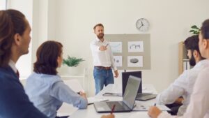 "Business coach using charts to measure ROI from business coaching during office presentation